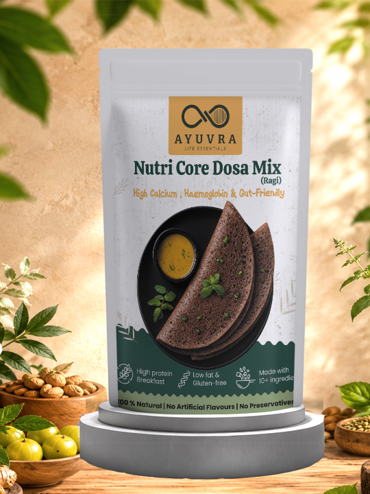 Packaging of Ayuvra Nutri Core Dosa Mix with a background of green leaves and wooden bowls.